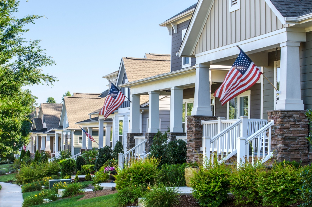 Suburban neighborhood with American flags hanging from porches