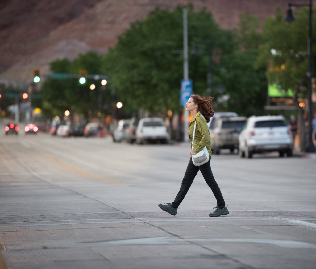 The woman walks alone across a street